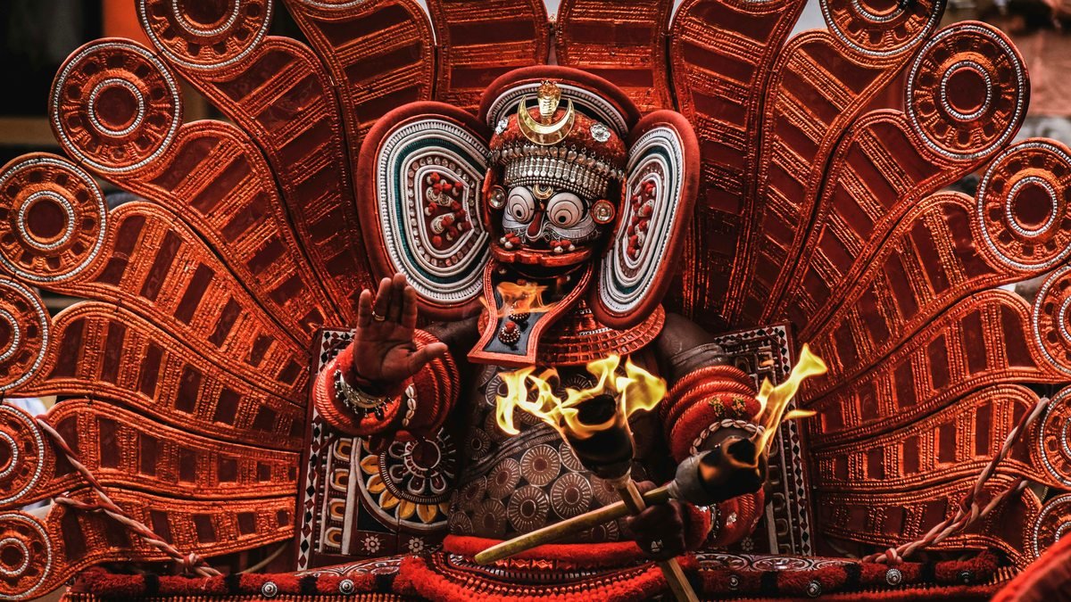 Theyyam performer in elaborate red and gold costume