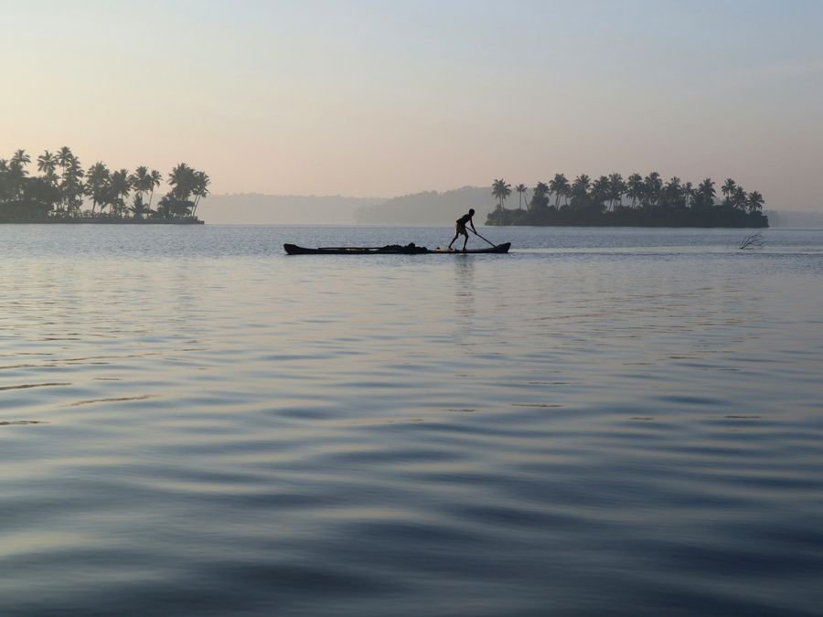 Misty silhouette of a canoe fisherman in Kerala